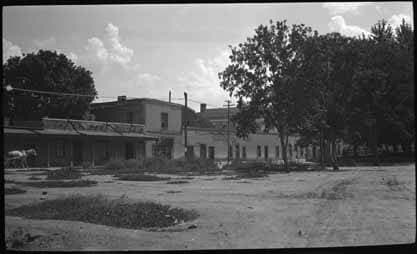 The block of Spanish Colonial buildings housing Prince Patio and Sena Plaza. Title: Prince Plaza and Sena Plaza Palace Avenur at Cathedra Place Santa Fe, NM. circa 1920-30. Photo: Palace of the Governors Photo Archive.